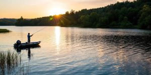 Fisherman on a lake at sunset, perfect fishing spot.